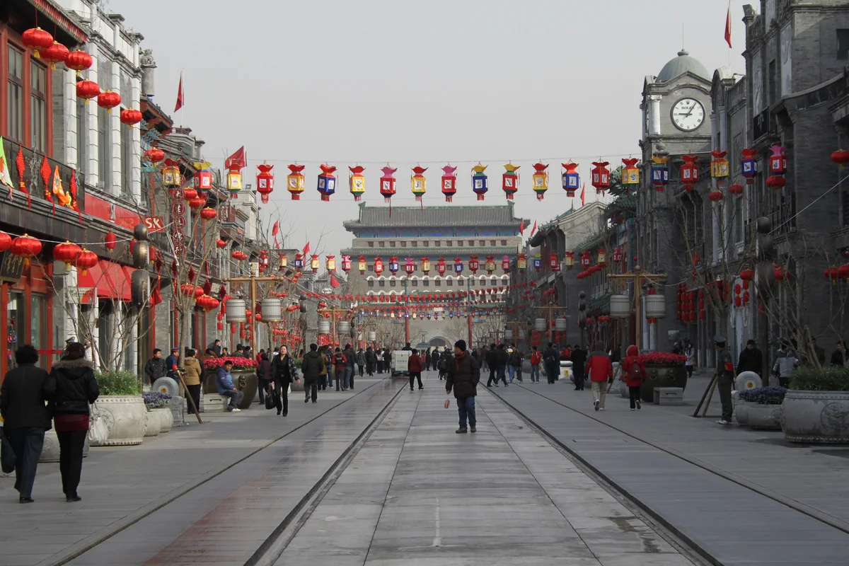 Qianmen Dajie pedestrian street hung with red lanterns, with the Qianmen gate tower at the far end