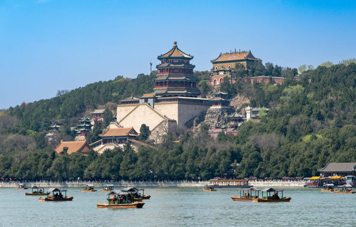 Longevity Hill and the Tower of Buddhist Incense rising above Kunming Lake, with small boats on the water