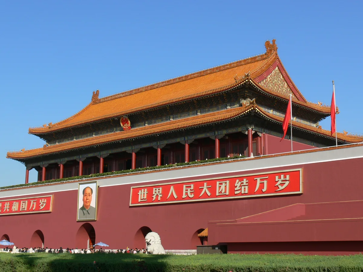 Tiananmen, the red Gate of Heavenly Peace with its double yellow-tiled roof and portrait, under a blue sky