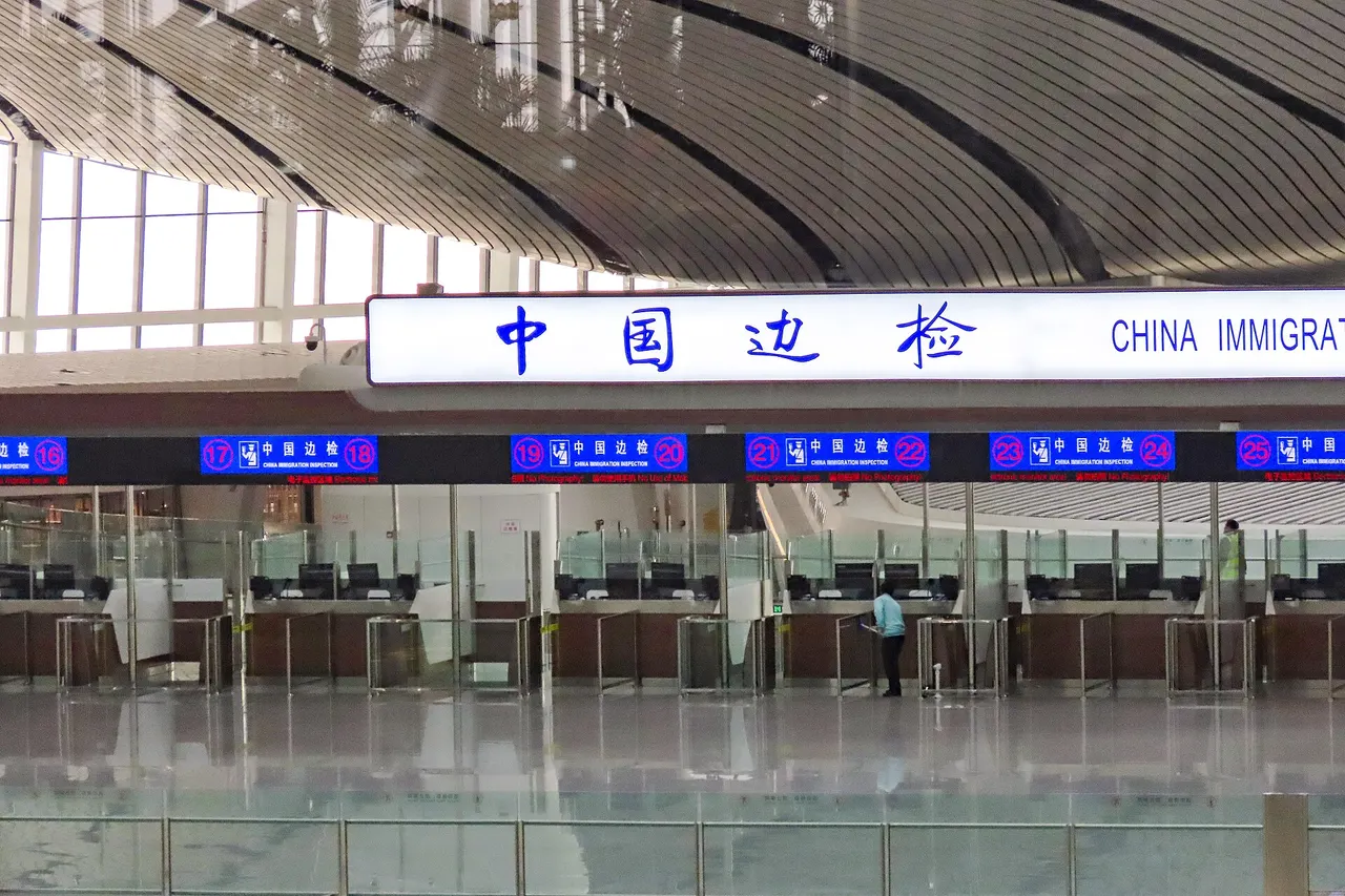 Rows of staffed border control desks under a sign reading China Immigration Inspection at Beijing Daxing airport