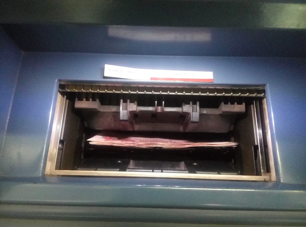 Pink 100-yuan notes in the cash slot of a Bank of China ATM in Hangzhou