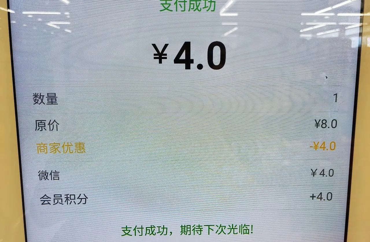 A supermarket self-checkout screen after a WeChat payment showing ¥4.0 paid after a ¥4.0 discount