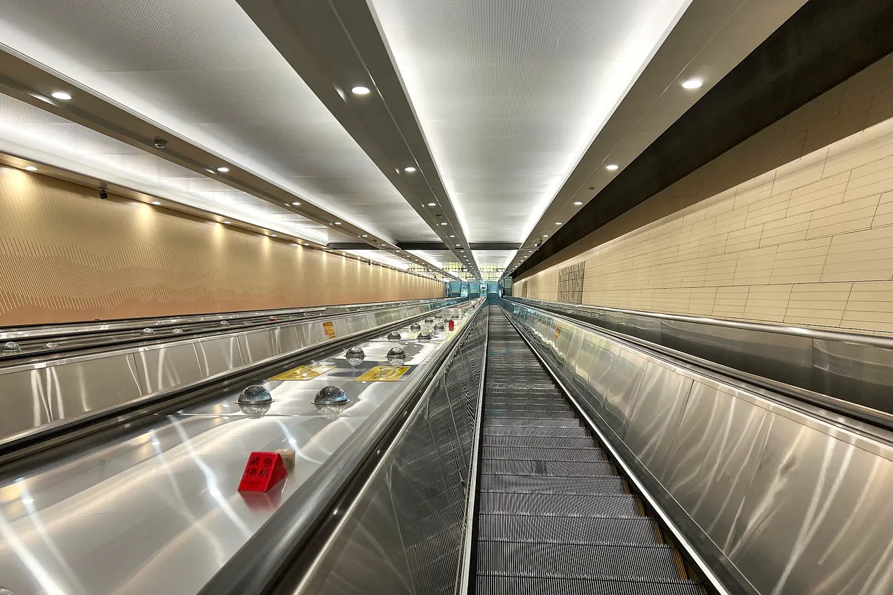 A long, steep escalator in a brightly lit tunnel at Badaling Great Wall railway station